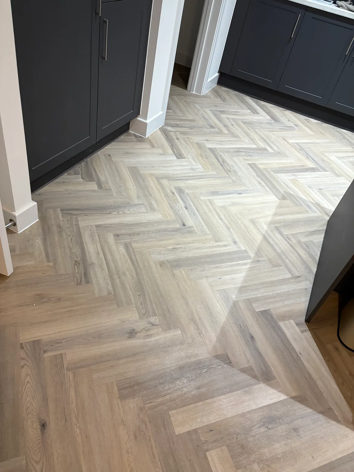 Pale herringbone flooring fitted in a customer's kitchen