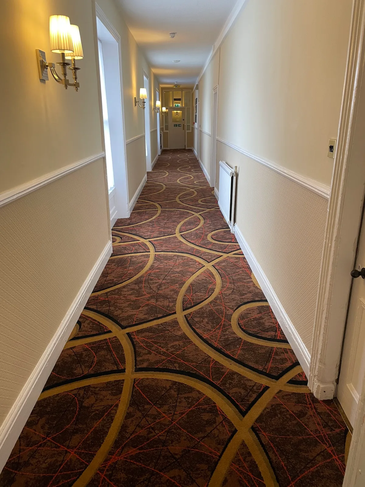 Bold patterned carpet fitted along a long corridor